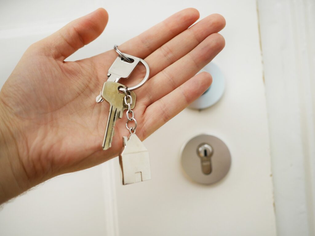Eine Hand, die einen Schlüssel hält (Immobilienübergabe)